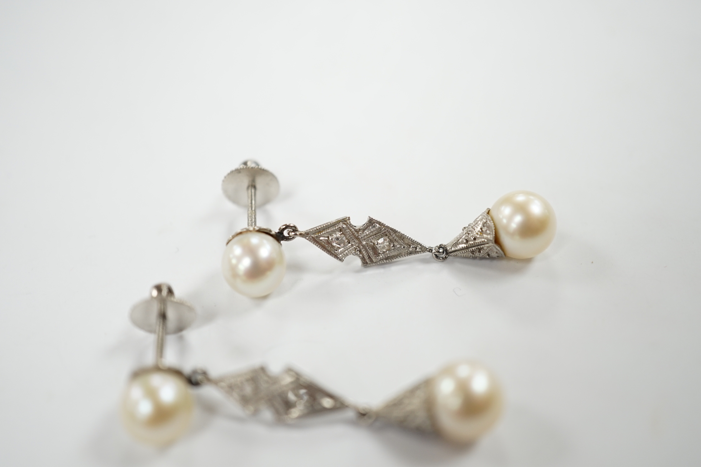 A pair of white metal, two stone cultured pearl and two stone diamond chip set drop earrings, 37mm, gross weight 6.1 grams.